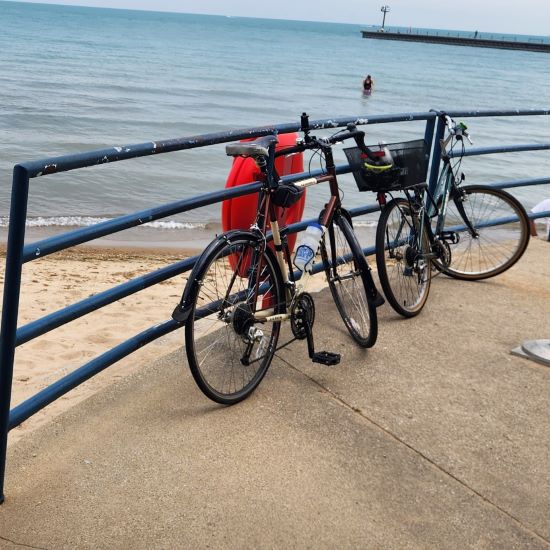 a bicycle locked to an iron fence alongside the beach