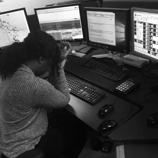 911 call-taker at the desk, head in hands