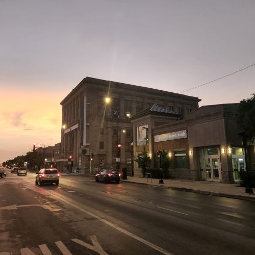 North Avenue at sunset, with a large old bank building in the background and a small modern bank in the foreground